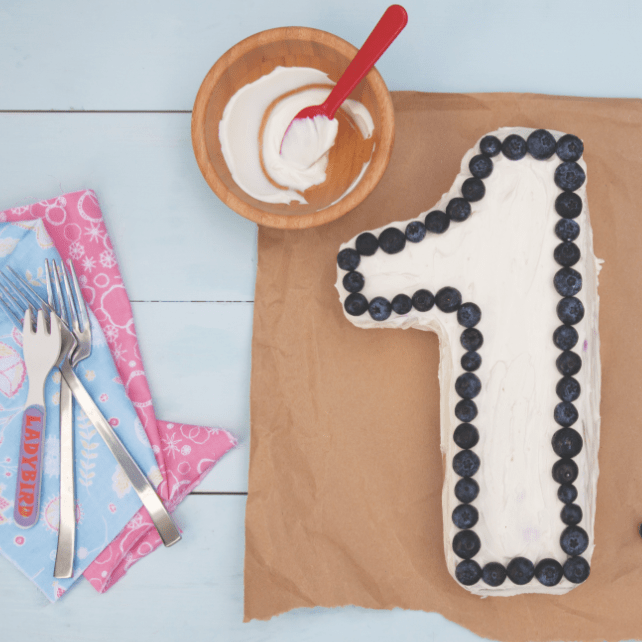 Birthday cake shaped in number 1 on wooden background