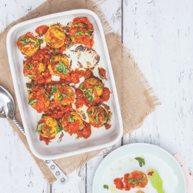 Moroccan meatballs in oven dish on wooden background